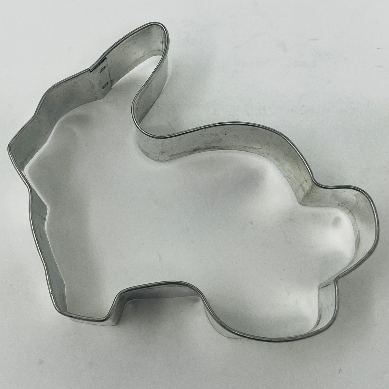 Mid-century metal cookie cutter shaped like a rabbit, ideal for adaptive use with a large handle, reflecting vintage kitchenware design.