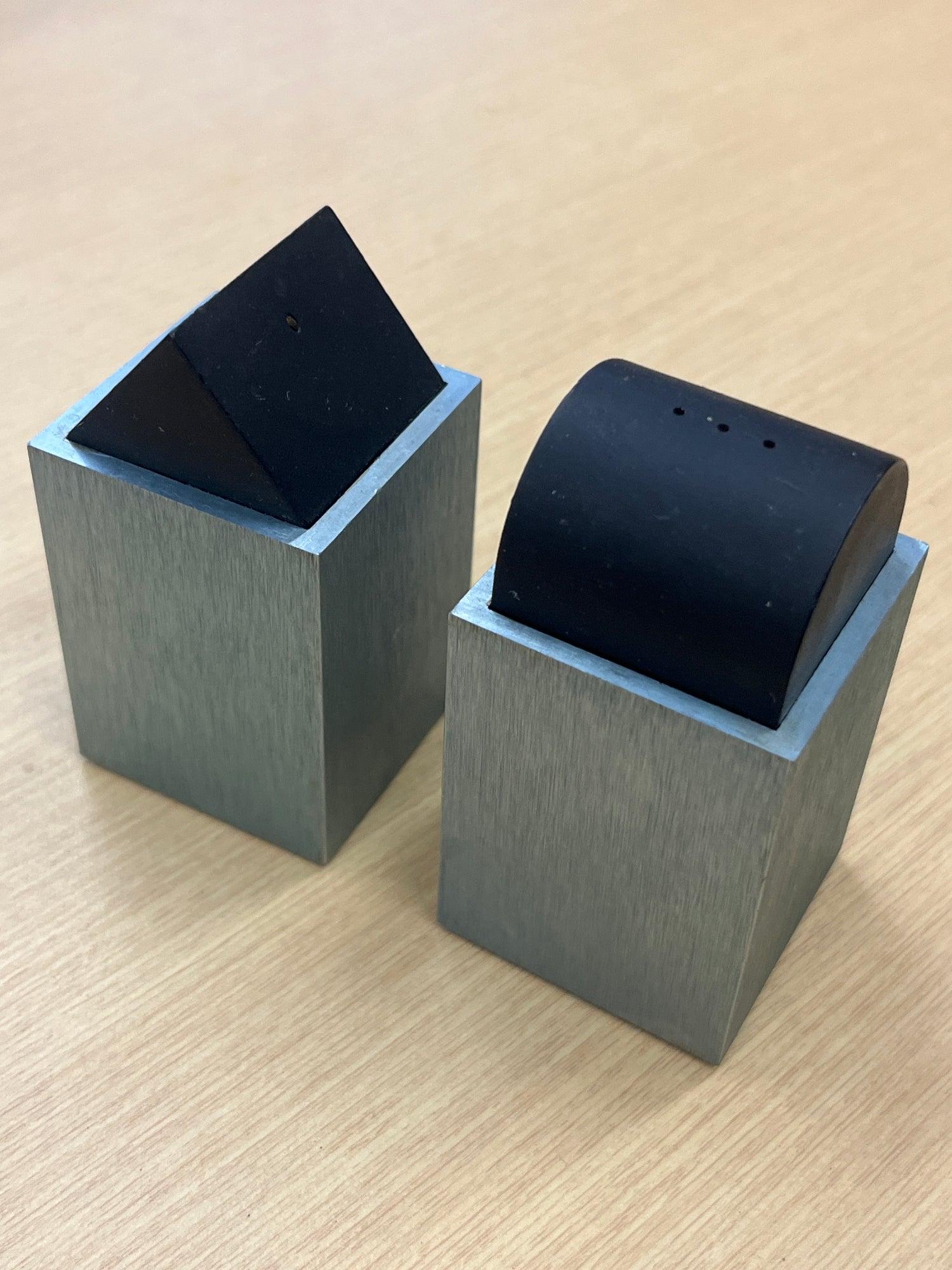 Elika anodized aluminum salt and pepper shakers by David Tisdale, featuring a geometric 1980s Memphis-style design on a wooden table.