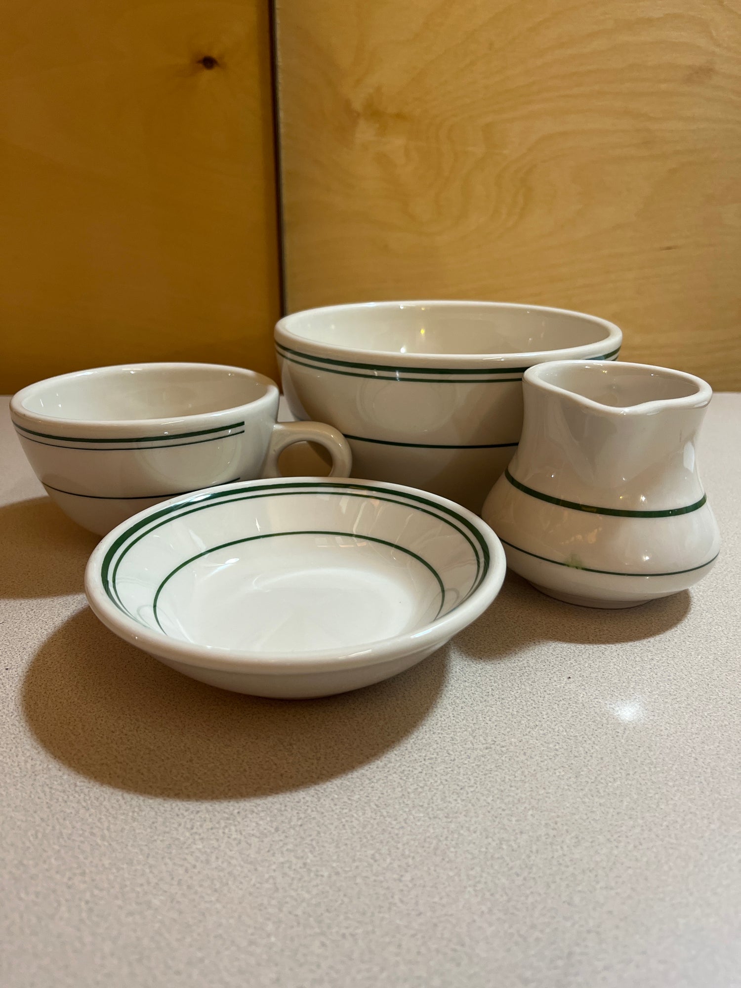 Homer Laughlin China set featuring plates, bowls, saucers, mugs, and creamer, elegantly arranged to showcase their classic design and craftsmanship.
