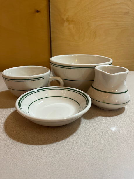 Homer Laughlin China set featuring plates, bowls, saucers, mugs, and creamer, elegantly arranged to showcase their classic design and craftsmanship.