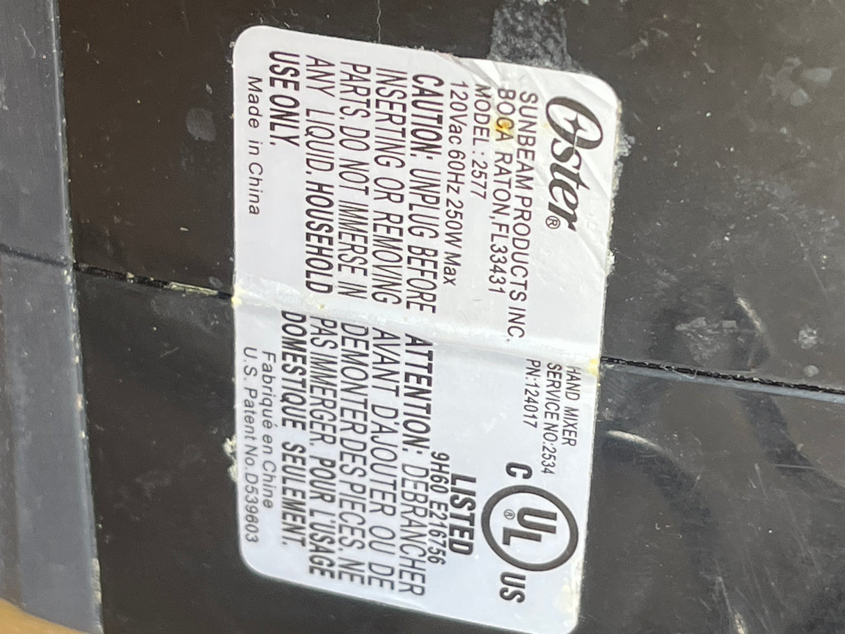 Oster 6-speed hand mixer, model 2577, with retractable cord, two whisk sets, and a 250W motor. Includes safety warnings and UL listing.