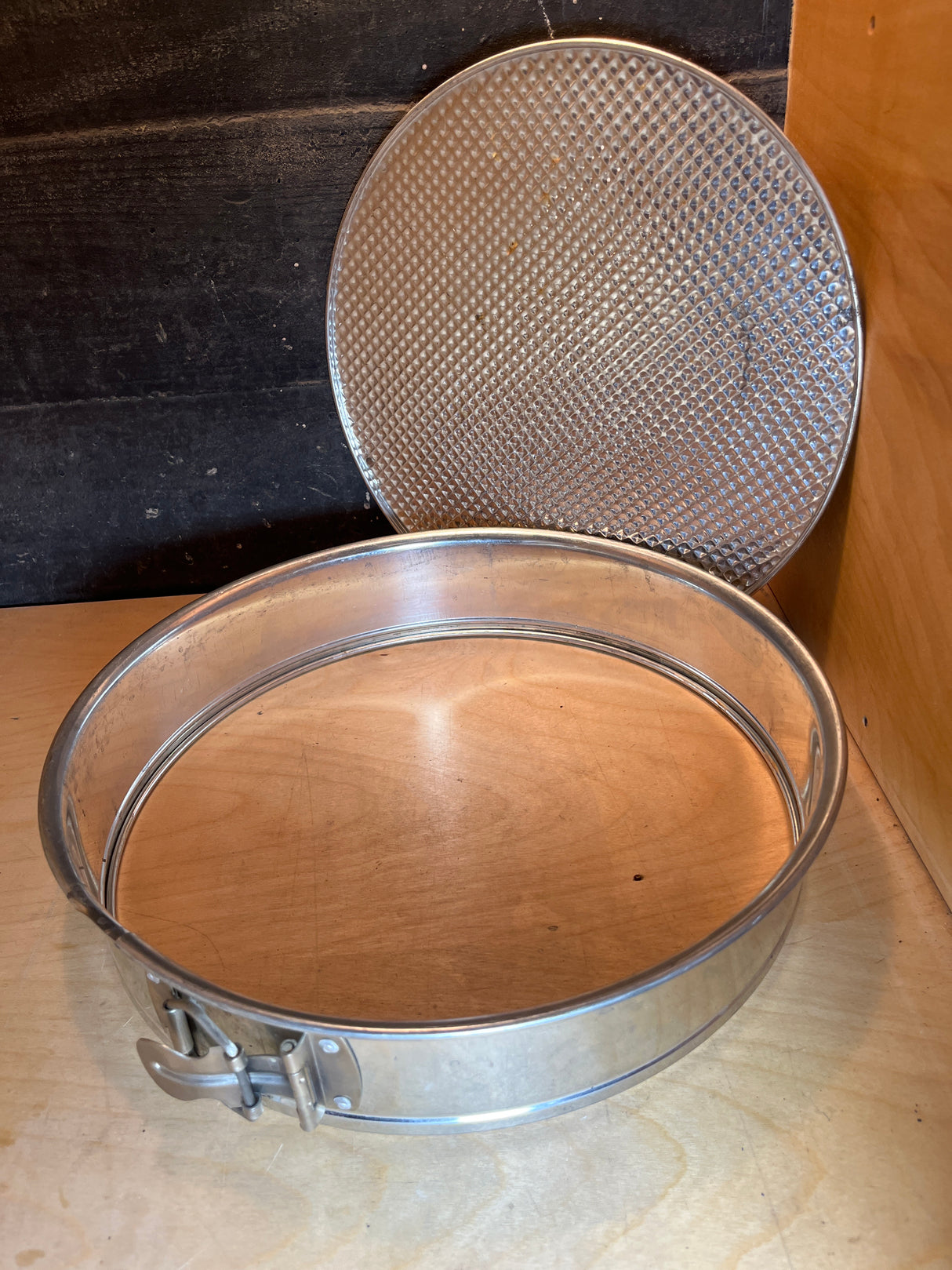 RARE Cold War springform cake pan - 12” tin made in W. Germany, showing unclipped sides and textured base on a wooden shelf, highlighting its historical uniqueness.