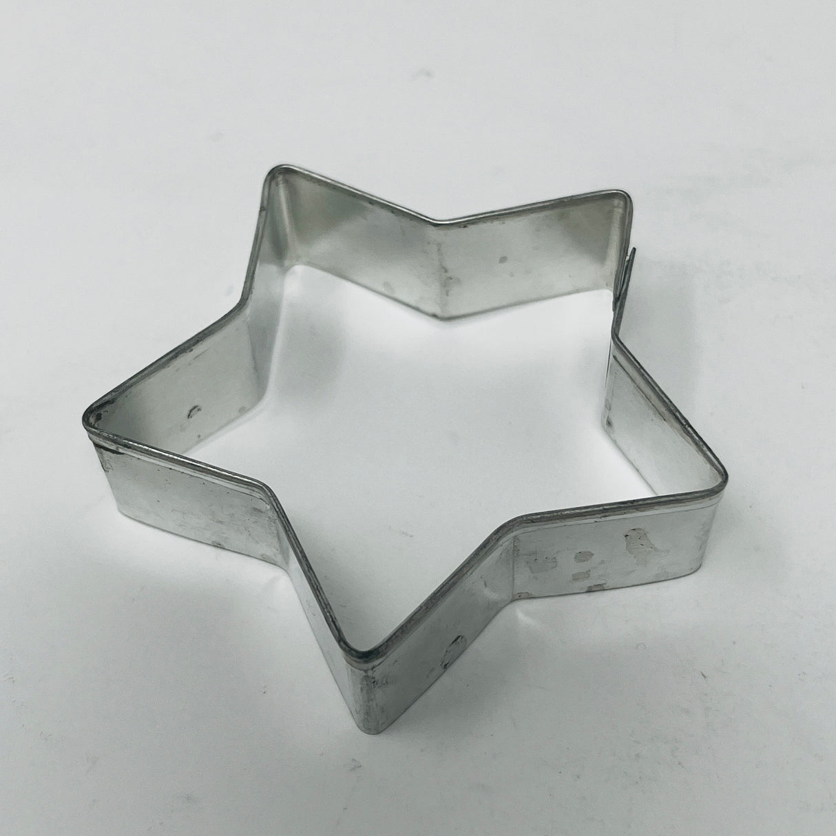 Mid-century metal cookie cutters with large handles for easy grip, featuring holiday and celestial shapes, including rare 1930s Pillsbury's Comicooky Cutter.