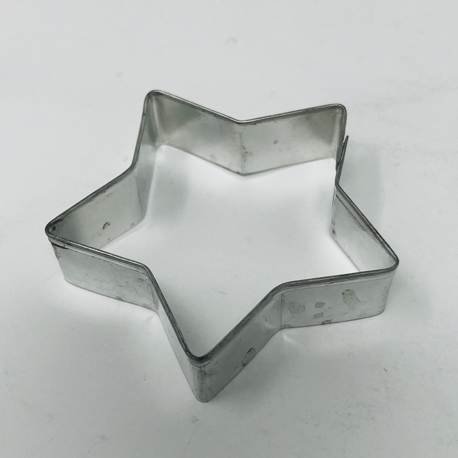 Mid-century metal cookie cutters with large handles for easy grip, featuring holiday and celestial shapes, including rare 1930s Pillsbury's Comicooky Cutter.