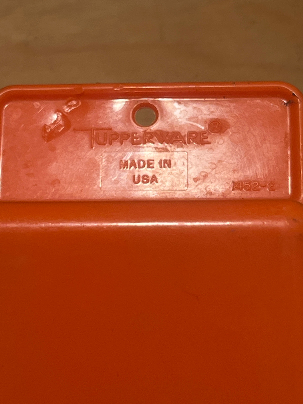 Orange pantry scoop - vintage plastic Tupperware, featuring Tupperware logo and “MADE IN USA,” perfect for scooping pantry essentials, with some scuffs on the handle.