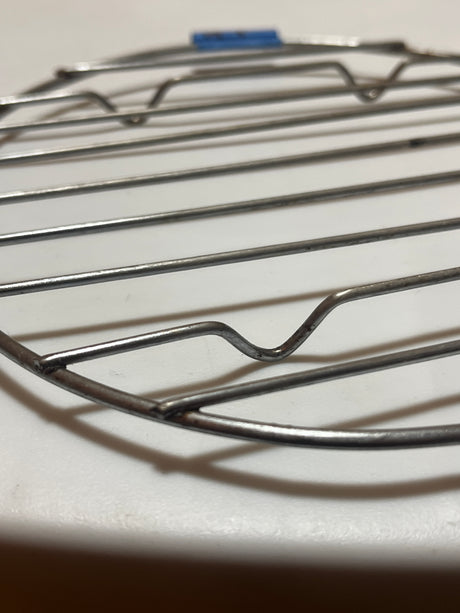 Small circular wire cooling rack with raised feet, designed for holding pots and pans. Suitable as a tray or cooling surface for kitchen use.