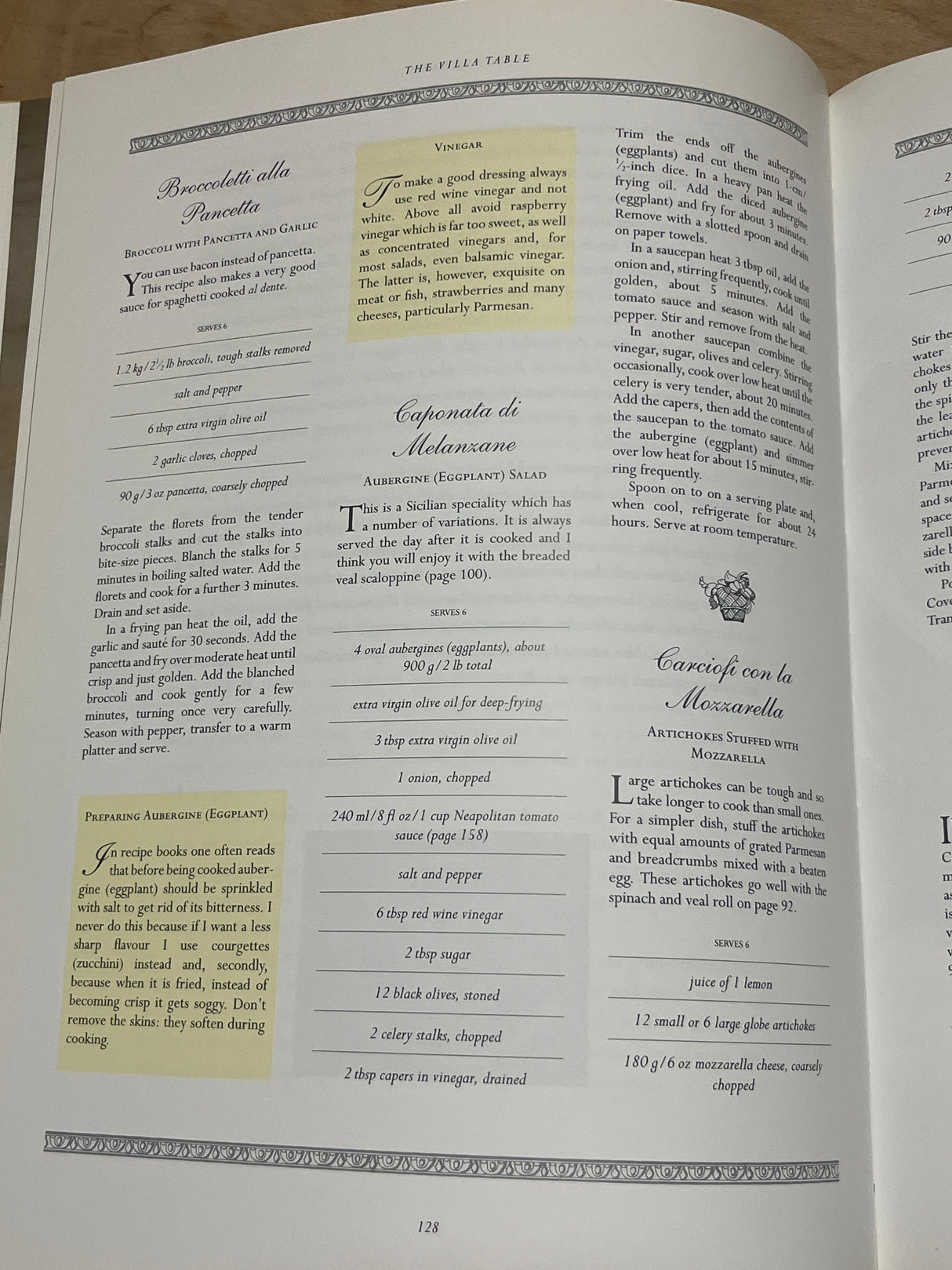 Italian cookbook spread from The Villa Table featuring recipes: Broccoletti alla Pancetta, Caponata di Melanzane, and Carciofi con la Mozzarella, with cooking tips. Page 128.