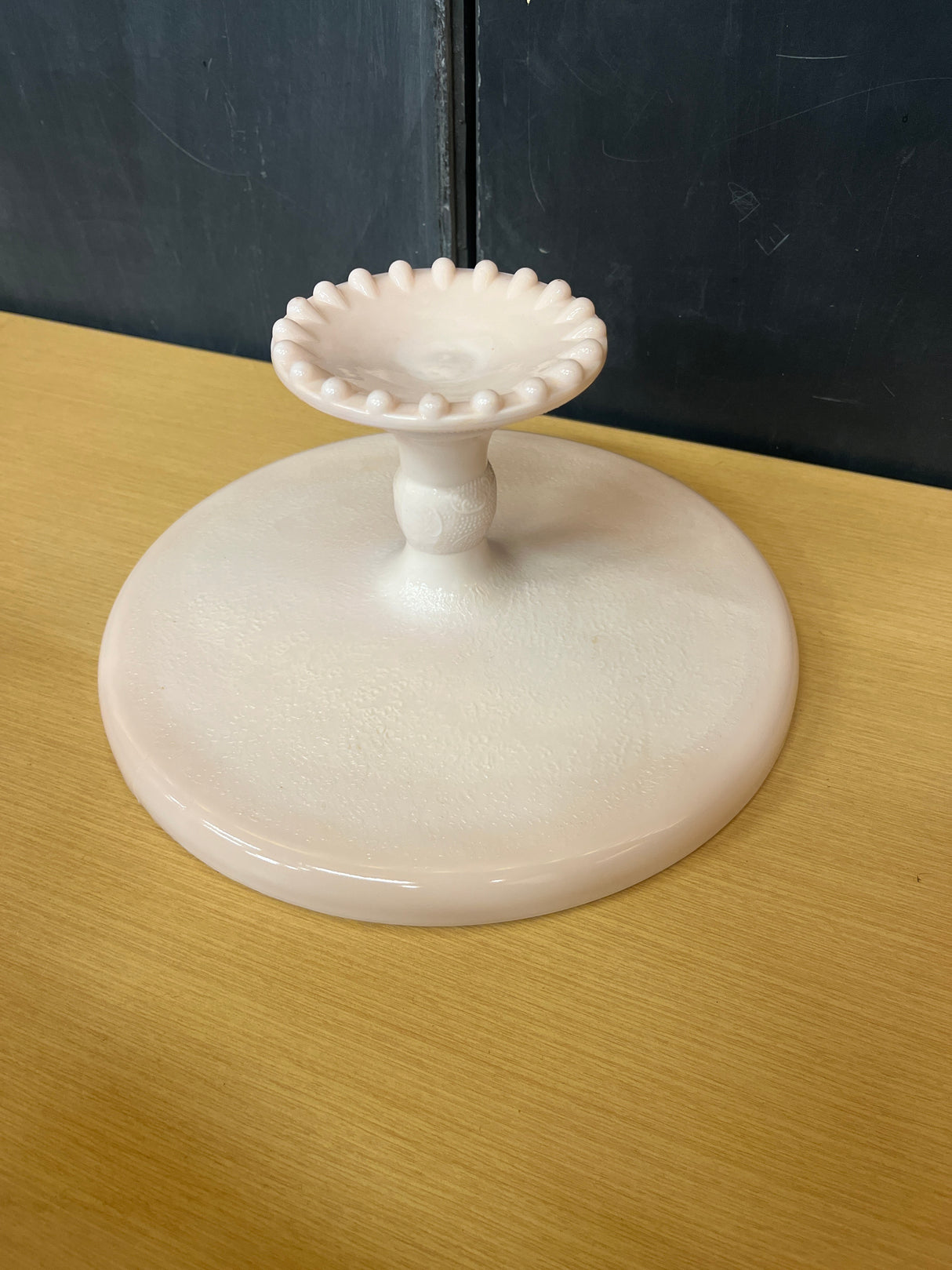 Jeanette pale pink milk glass pedestal candy dish with a geometric crisscross pattern and raised bumps, showcasing a vintage 1950s-1960s design.