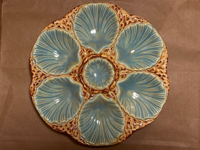 RARE French majolica oyster plate with scallop-shaped wells and central sauce well, showcasing antique craftsmanship with intricate detailing and a gentle patina.