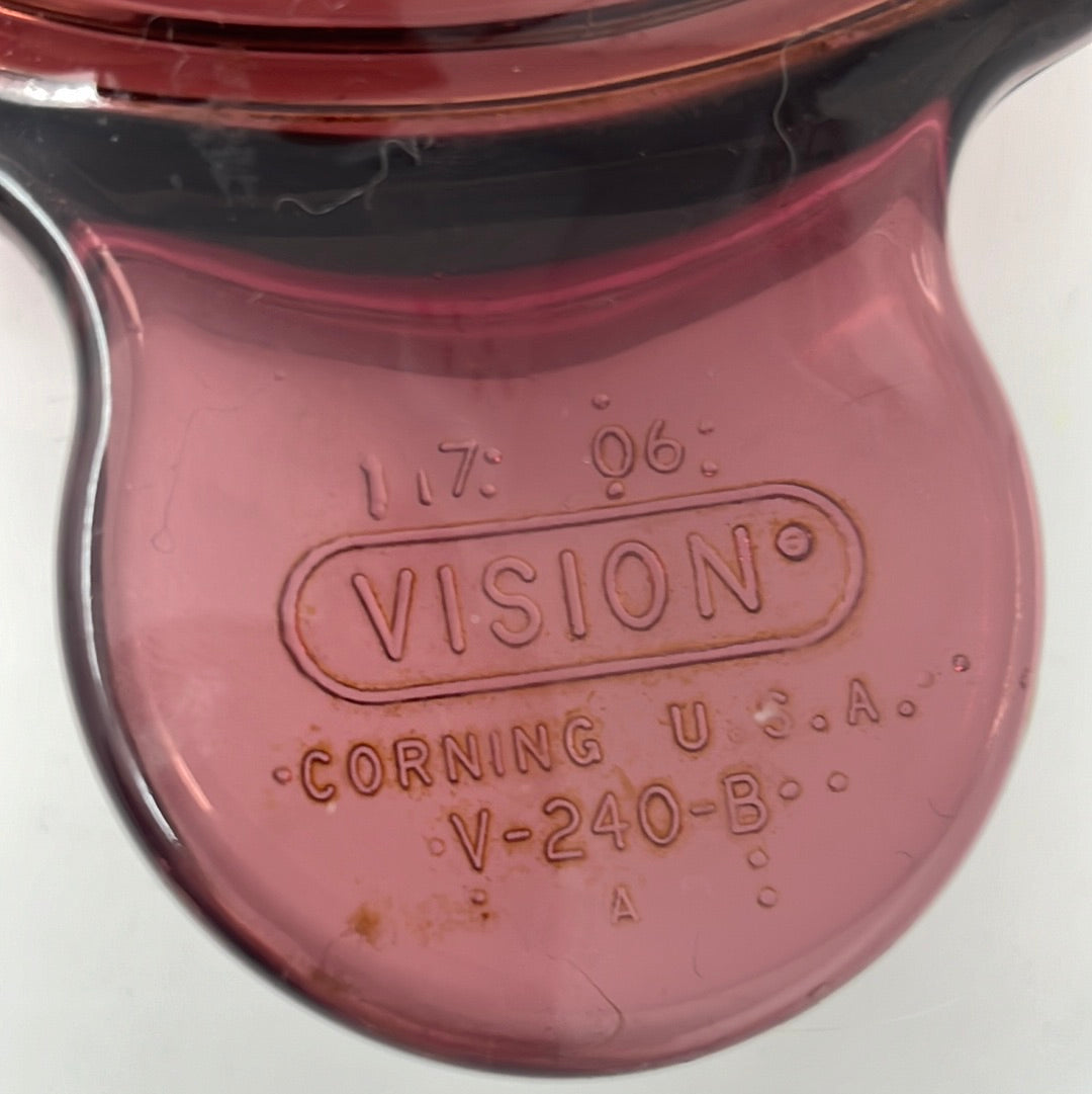 Close-up of a versatile Cranberry Vision Ware pot with lid.