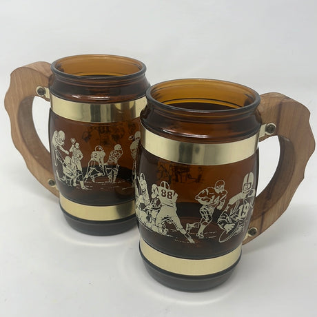 Two brown glass barrel mugs with wooden handles, perfect for enjoying beverages in retro style. Set of 2 Fiesta Ware mugs for beer or root beer.