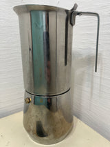 Ilsa Turbo Express 6-Cup 18/10 stainless steel stovetop espresso pot on countertop, showcasing its sleek design and noted tarnishing around the base.