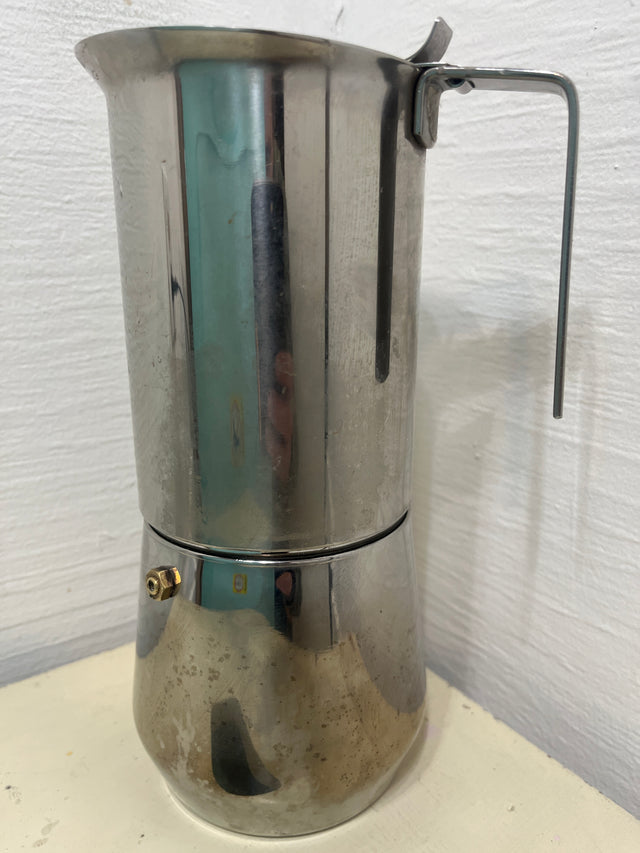 Ilsa Turbo Express 6-Cup 18/10 stainless steel stovetop espresso pot on countertop, showcasing its sleek design and noted tarnishing around the base.