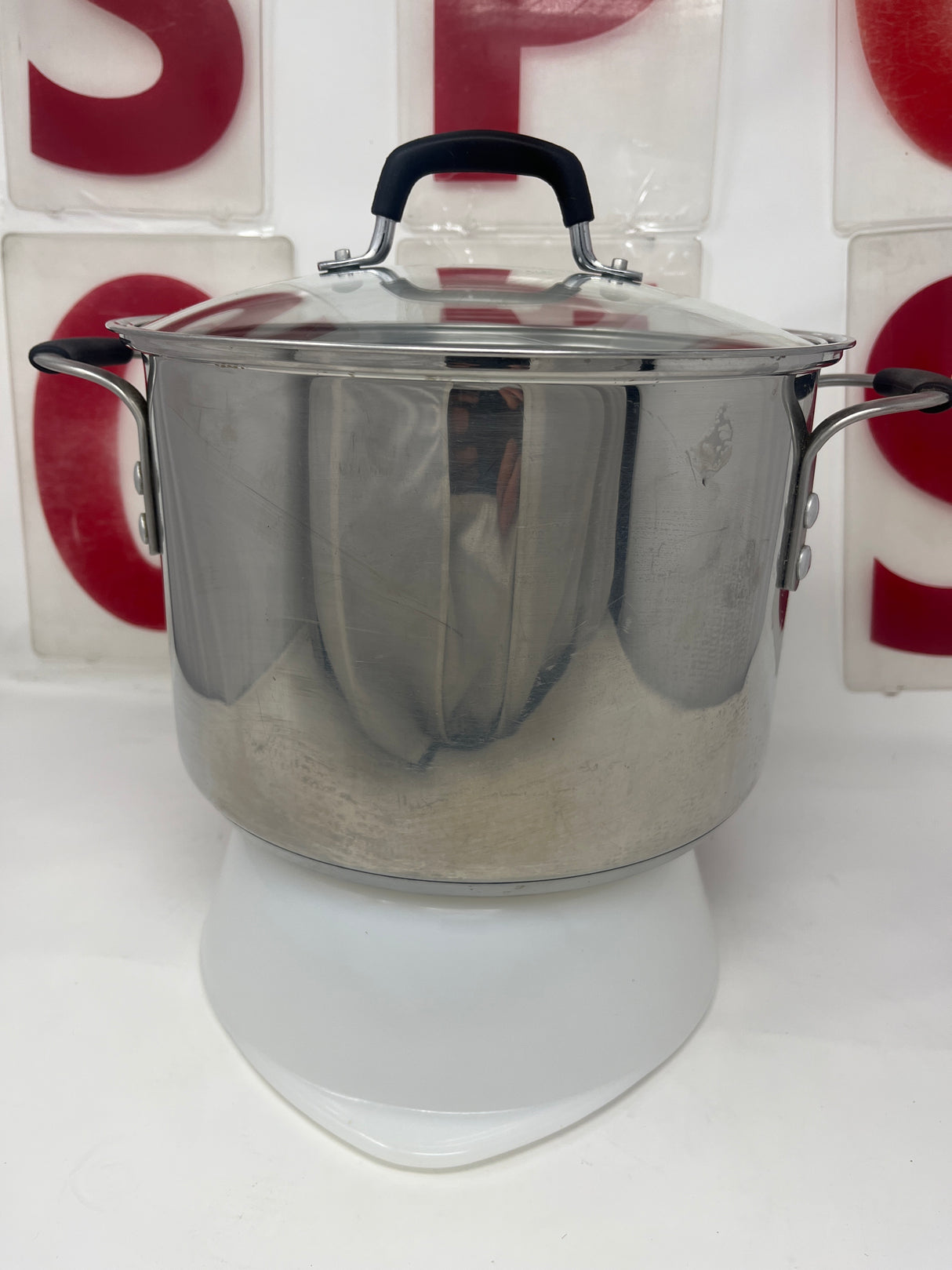 Calphalon 8608 8 qt. stock pot with lid featuring silicone handles, shown on a white stand, ideal for kitchenware use.