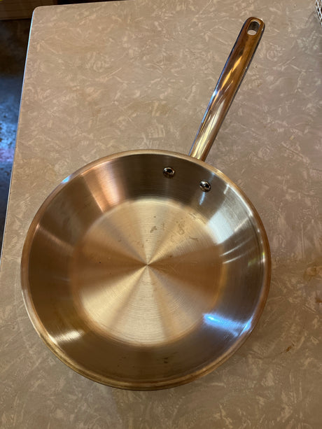 8 inch stainless steel frying pan - Made by Design Target, with flared sides and riveted handle, on a kitchen countertop for easy cooking tasks.