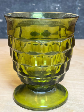 Whitehall Indiana green cubist glass, a small pressed glass goblet with geometric block pattern on the bowl, featuring a round pedestal base.