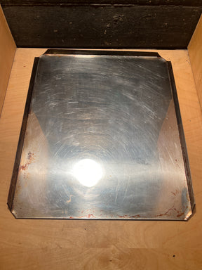 Stainless steel baking pan - vintage Sears with a shiny, slightly scratched surface, featuring low metal lips, resting in a wooden drawer.