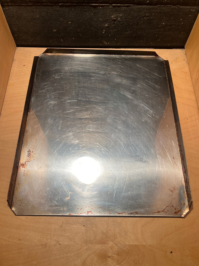 Stainless steel baking pan - vintage Sears with a shiny, slightly scratched surface, featuring low metal lips, resting in a wooden drawer.