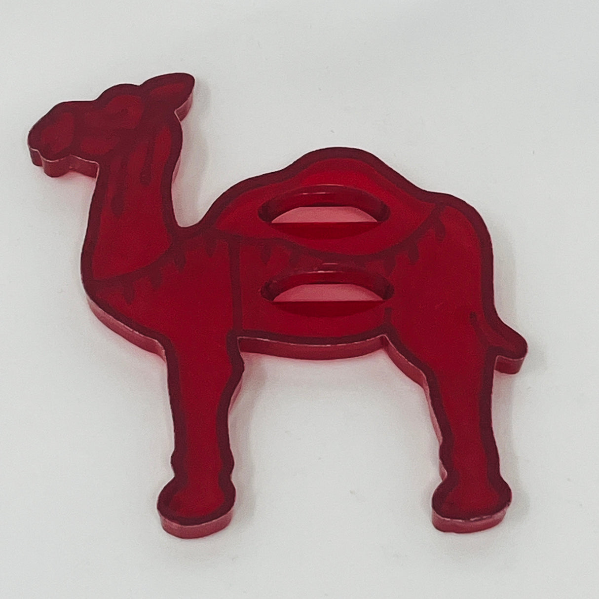 Red plastic mid century cookie cutters shaped like a camel, horse and more, some with a Crown logo.