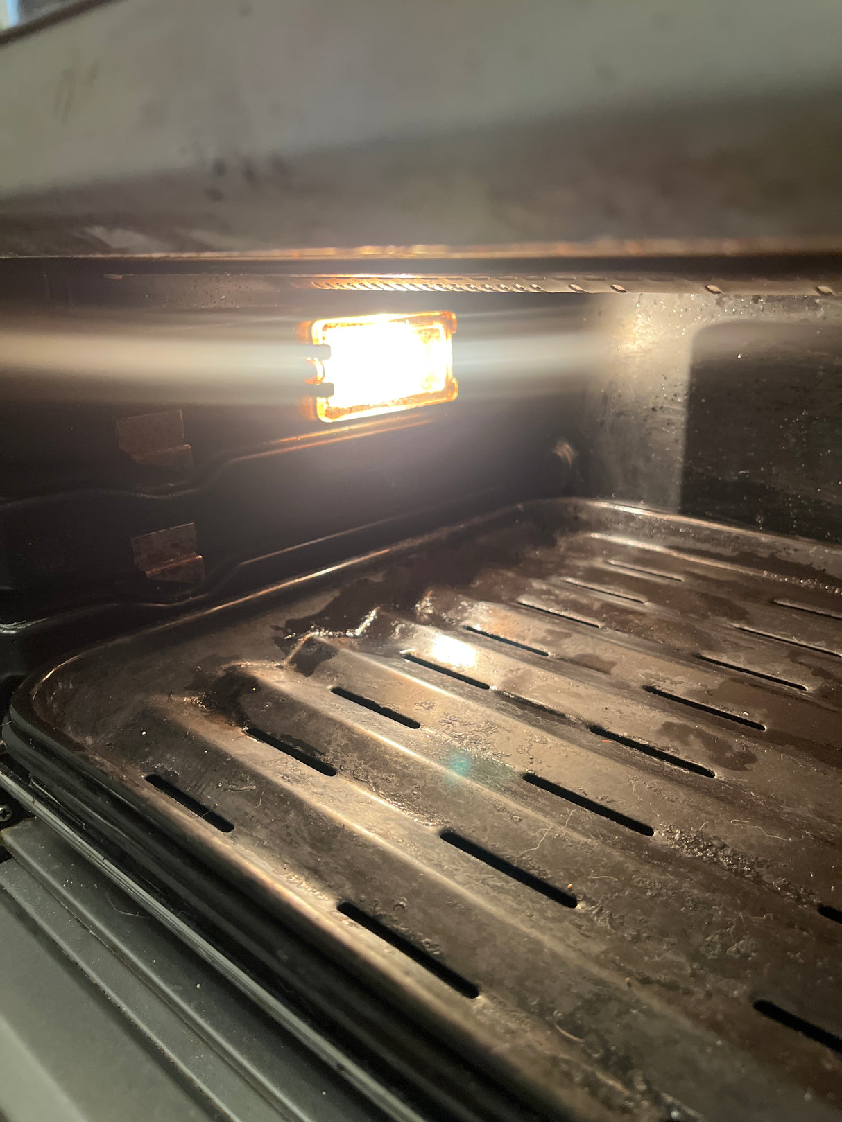 Close-up of a Breville oven featuring its grill and interior light, showcasing the appliance's sleek, steel design suitable for modern kitchens.