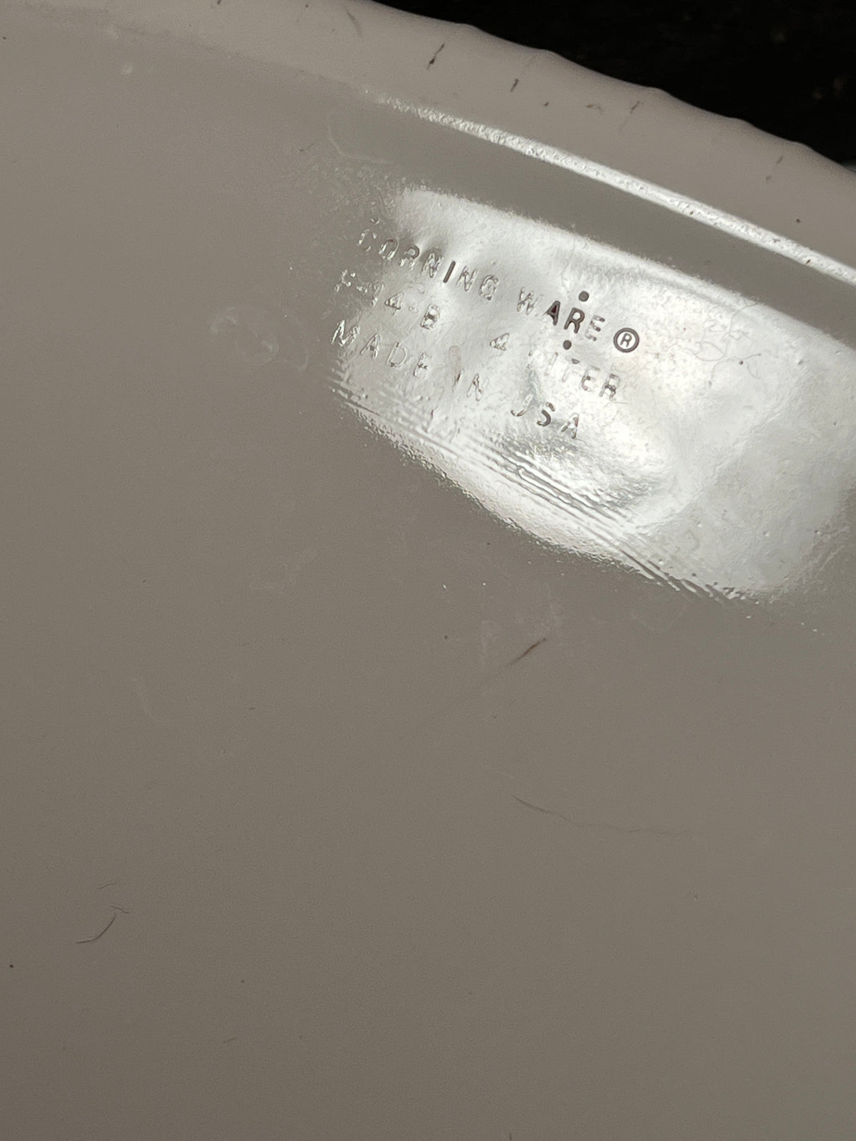 Close-up of the underside of a 4-liter oval casserole dish with lid - PYREX Corning Ware French White F-14-B, showing the CORNING WARE® … MADE IN USA markings.