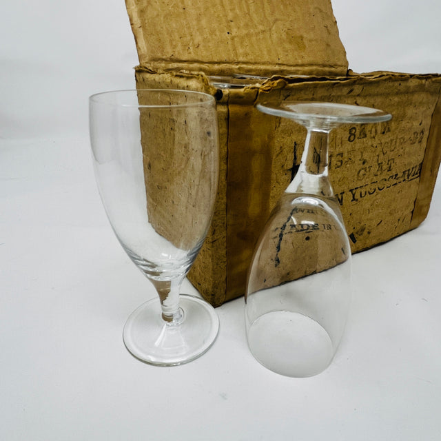 Yugoslavian sherry glasses set of 8, two empty glasses displayed in front of box. From Spoons Kitchen Exchange.