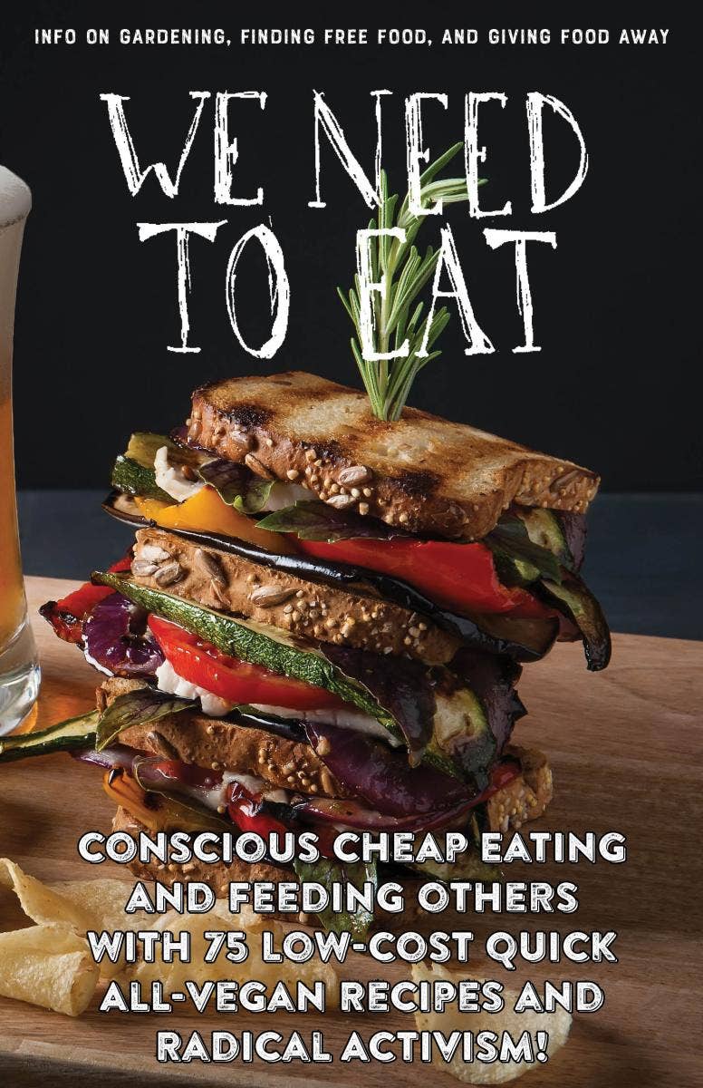 Cover of “We Need To Eat!” zine featuring a multi-layered vegan sandwich, highlighting gardening, free food, and activism with 75 vegan recipes.