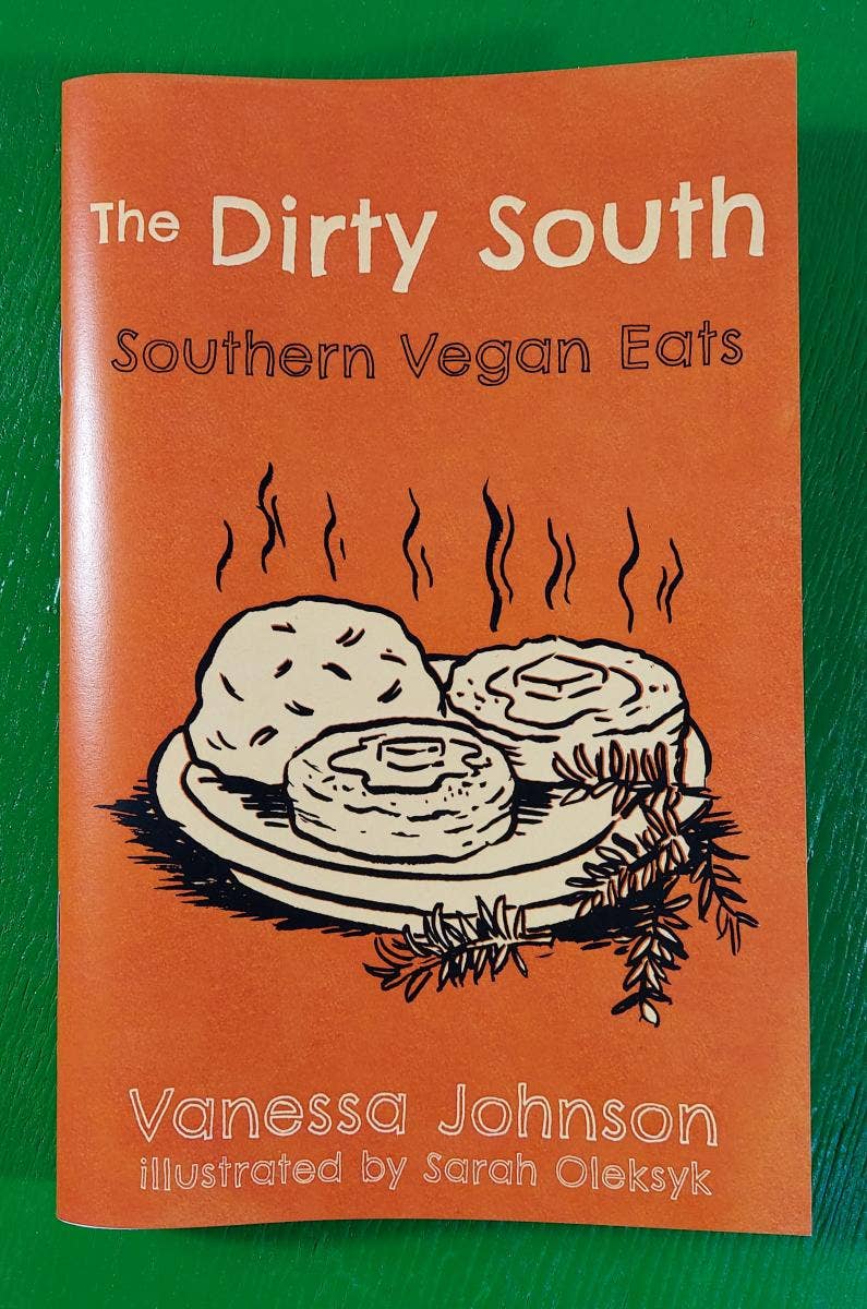 Cover of The Dirty South: Southern Vegan Eats zine, featuring steaming biscuits illustration by Sarah Oleksyk. Authored by Vanessa Johnson, offering 64 pages of vegan southern recipes.