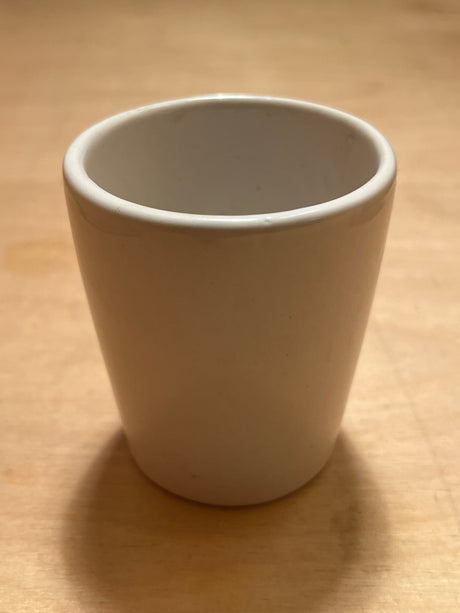 Teeny weeny espresso cup, a small white ceramic tumbler with smooth sides and a rounded rim, ideal for a single espresso shot.