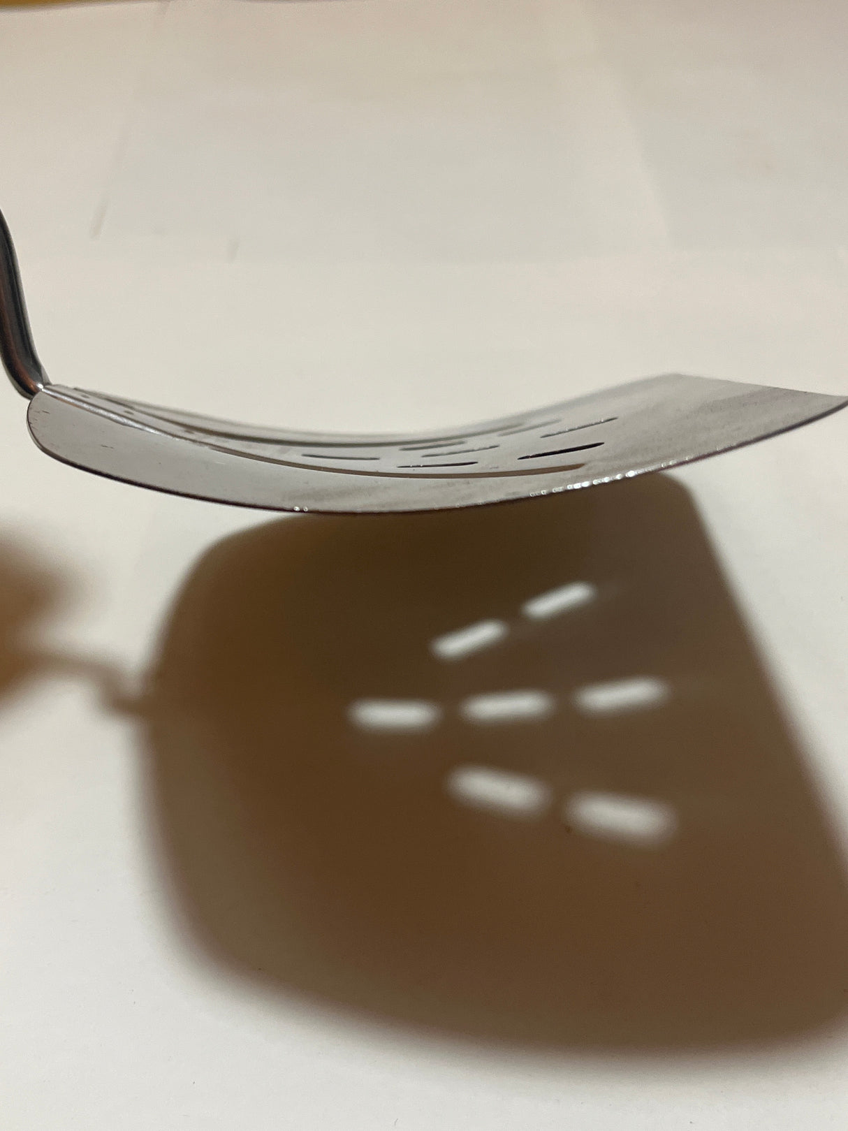 Foley Stainless Steel Wide Slotted Turner Lifter MPLS Curved Spatula, showcasing a thin, sturdy blade with rectangular slots and a well-preserved resin handle.