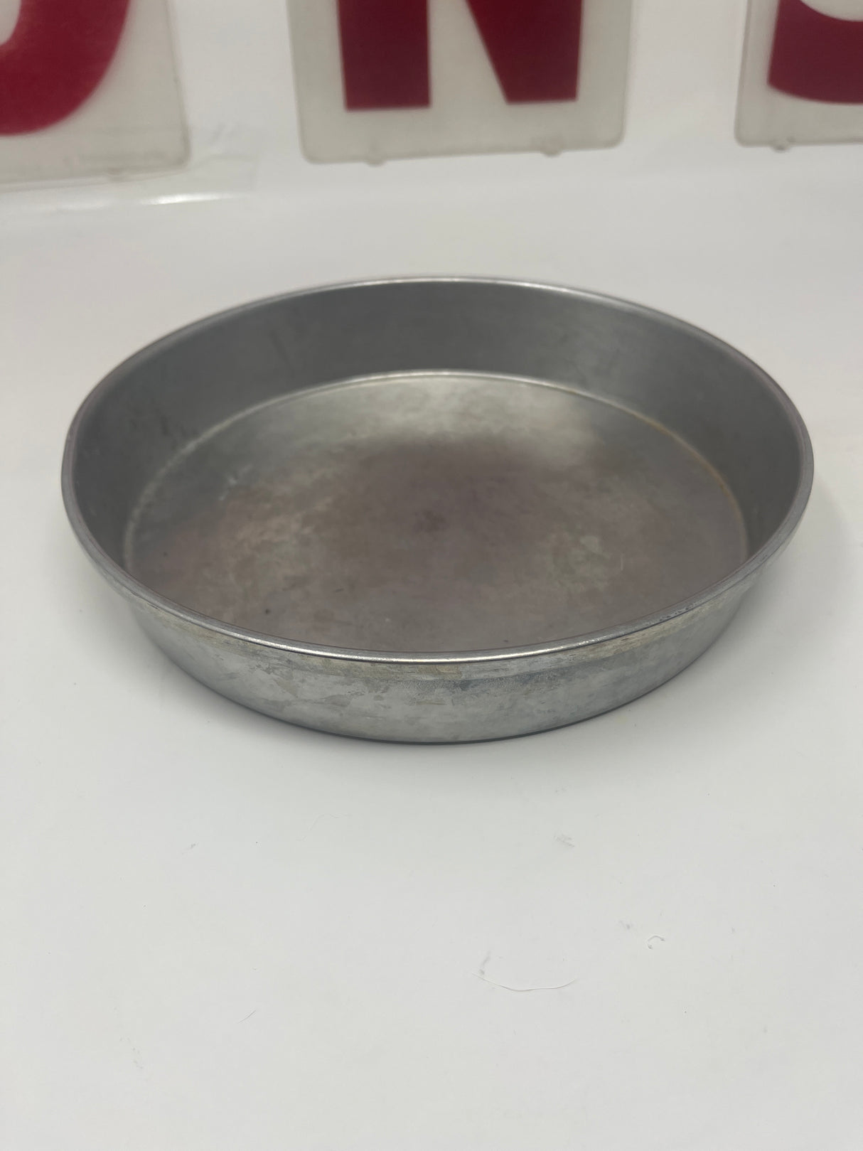 Wear-Ever 8 round aluminum cake baking pan, vintage, in excellent condition, lies flat with no rust, displayed on a white surface.