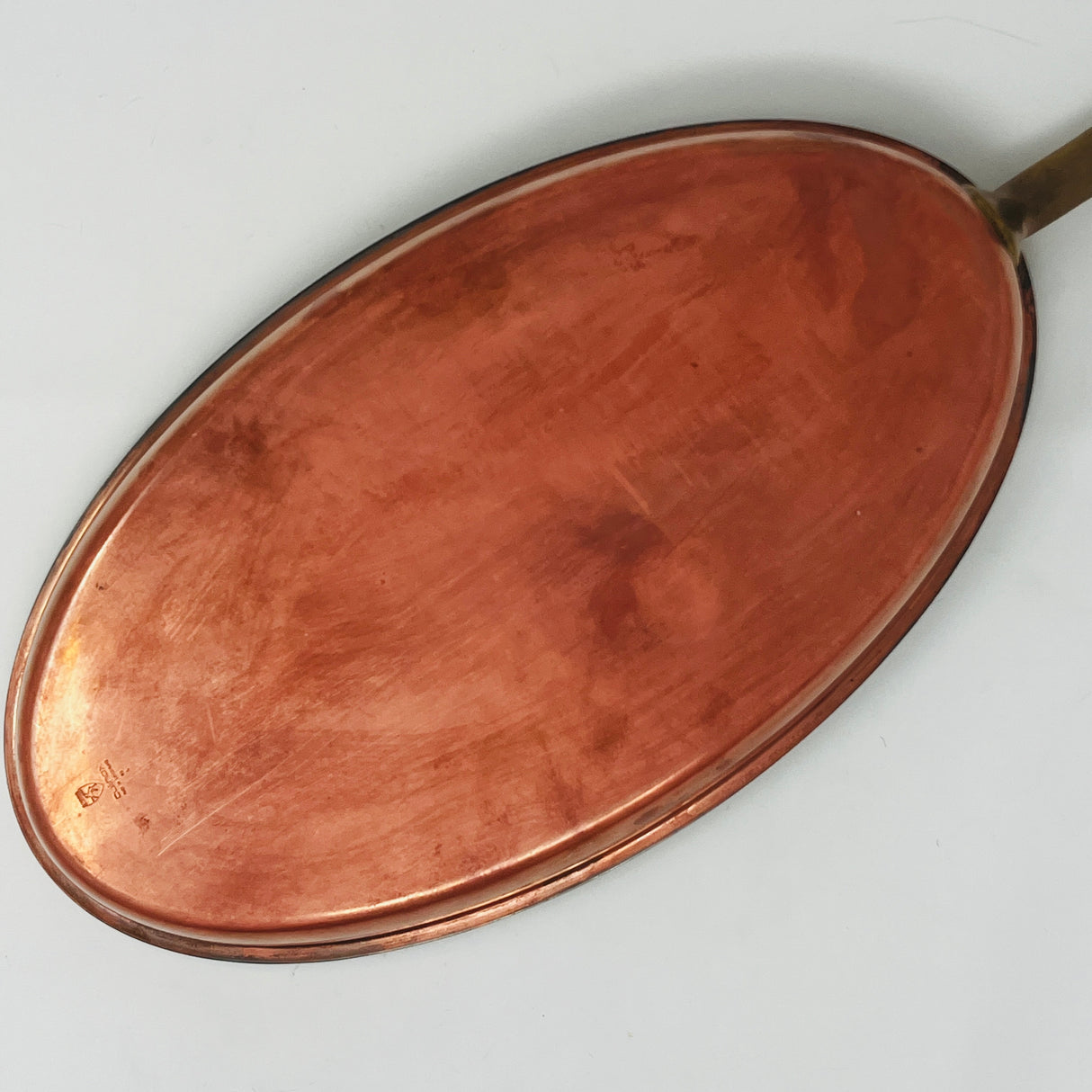 Underside of oval copper sauté pan with brass handle, Spring Culinox Switzerland. From Spoons Kitchen Exchange.