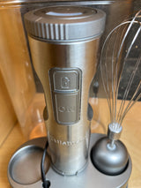 Cuisinart stick blender and whisk set HB-800PC, with stainless steel blender and whisk attachments, rests in a compact stand with visible controls.