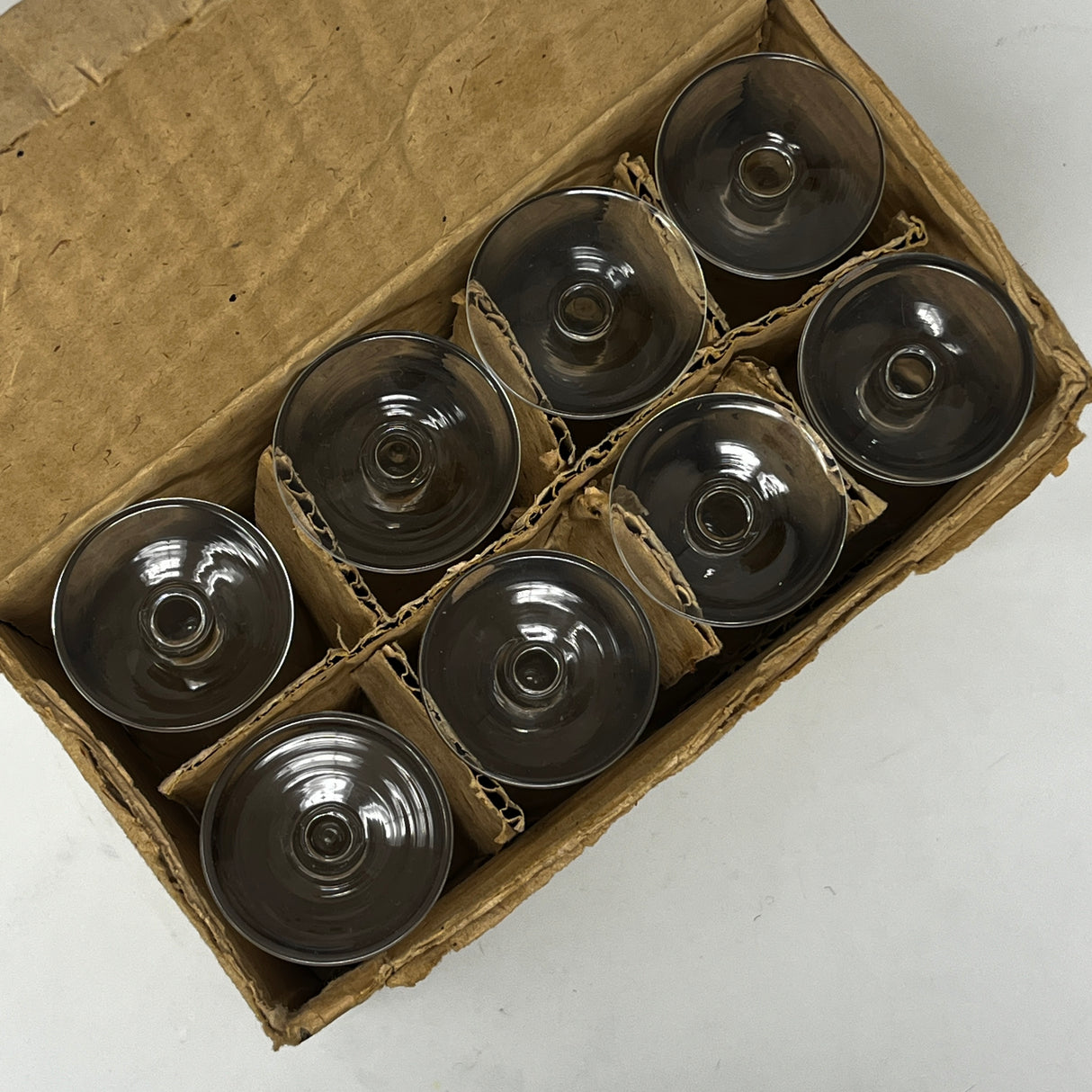 Yugoslavian sherry glasses set of 8 in original box, delicate glassware in impeccable condition. View of glasses stored in box with protective packaging. From Spoons Kitchen Exchange.