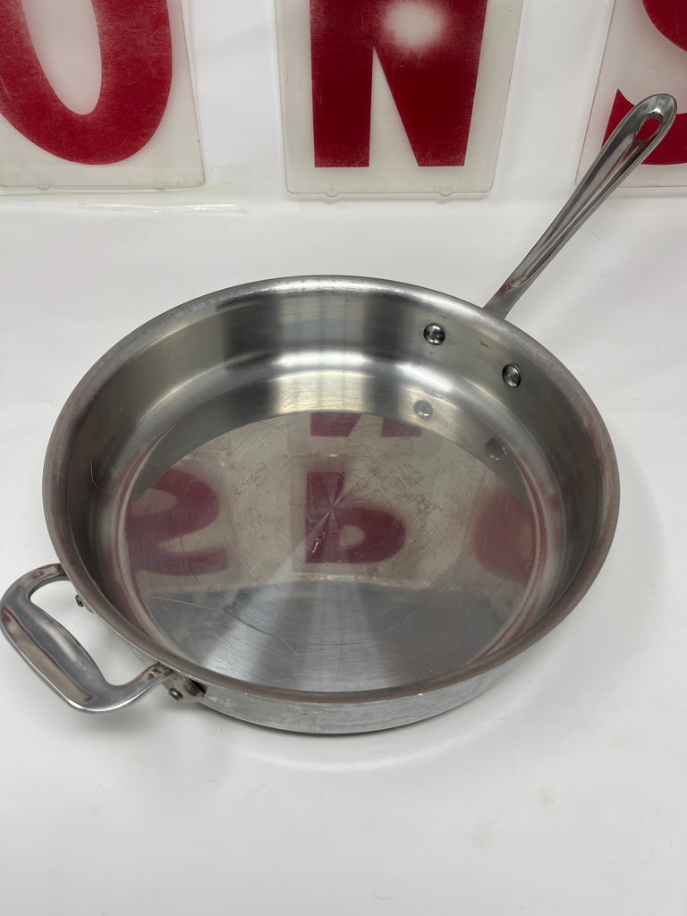 All-Clad Stainless Steel 11 Inch Sauté Pan with Double Handle, featuring a wide base and deep sides. No lid included.