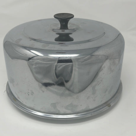 Vintage stainless steel food cloche, large enough for a dinner plate or platter, featuring a metal lid and black handle. From Spoons Kitchen Exchange.