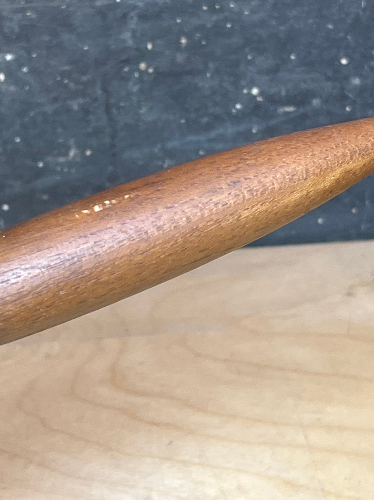 Close-up of a vintage Michael Lax Copco yellow enamel fondue pot, highlighting its smooth surface and tapered design, set against a light wood background.