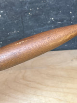 Close-up of a vintage Michael Lax Copco yellow enamel fondue pot, highlighting its smooth surface and tapered design, set against a light wood background.