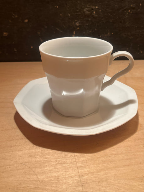 White ceramic octagonal teacup and saucer from the Savoir Vivre Maison Blanche line, elegantly displayed on a wooden surface, highlighting its sophisticated design.