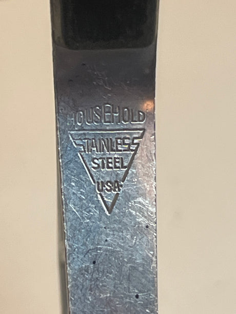 Potato masher with black handle - Household Stainless Steel USA, featuring a stamped logo and notch for hanging. Vintage design, decorative yet functional for kitchen use.