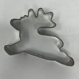 Mid century metal cookie cutter in moose shape on white surface.