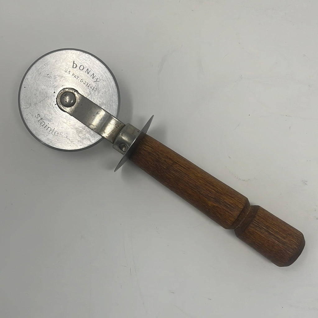 Stainless steel Bonny USA rolling pastry and pizza cutter with wood handle, featuring an inscription US PAT D-23413.