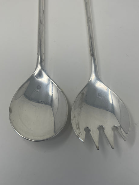 Italian silver plated salad tongs, 1970s design, with slight tarnish. Image: Close-ups of silver spoons and tongs on white surface.