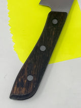 Vintage santoku chef’s knife with 5.75” steel blade and wooden handle, featuring a small handle chip, offering expert precision and unique character.