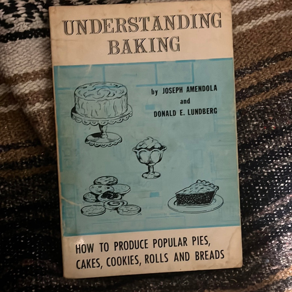 Book cover for Understanding Baking displaying drawings of cakes, pies, and pastries on a light blue backdrop. From Spoons Kitchen Exchange.