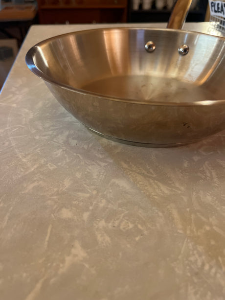 8-inch stainless steel frying pan by Made by Design Target, featuring flared sides and riveted handle, on a kitchen countertop. Perfect for versatile cooking.