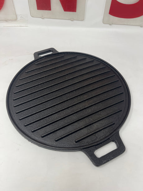 Cast iron ridged grill pan with handles, designed for gas stoves and outdoor grills, ideal for searing paninis, veggies, and plant-based proteins.