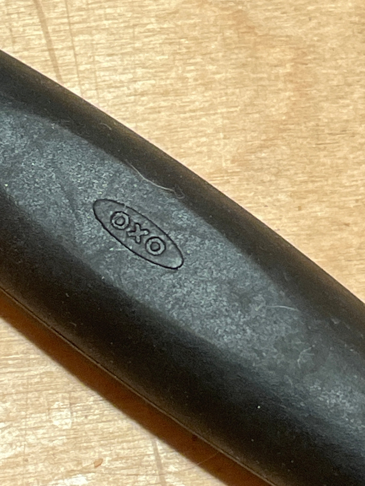 Melon baller with silicone handle - OXO Good Grips, featuring a black, rubberized handle embossed with OXO for a secure, non-slip grip.