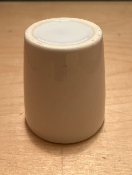 Teeny weeny espresso cup set upside-down, showcasing its unglazed base. Perfect for a single espresso shot, adding charm to your cafe table.