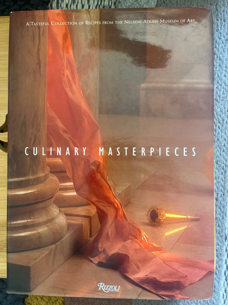 Book cover featuring Culinary Masterpieces: A Tasteful Collection of Recipes from the Nelson-Atkins Museum of Art, with a red cloth, a cone, and a captivating blend of diverse recipes for varied lifestyles.